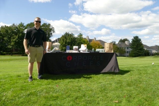 A man stands in front of a table that says corporate