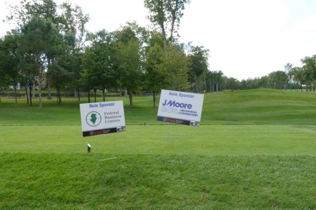 Two signs on a golf course one of which says j. moore