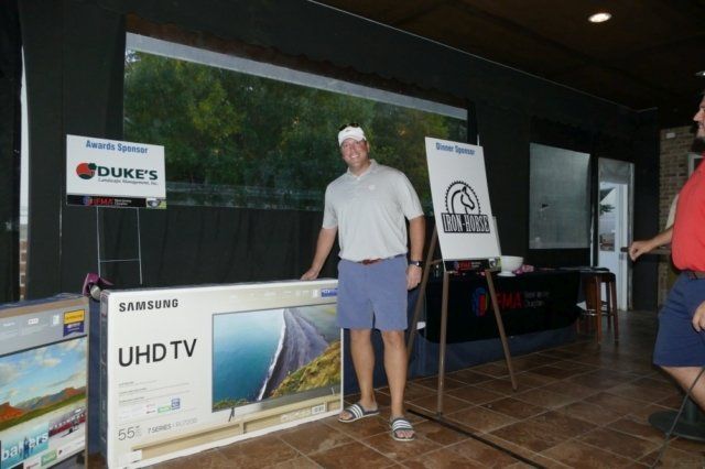 A man is standing in front of a samsung uhd tv