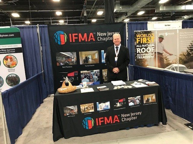 a man is standing in front of a ifma booth .