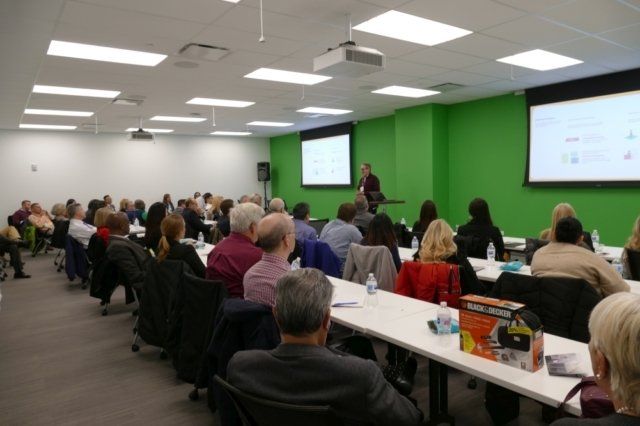 A man is giving a presentation to a large group of people