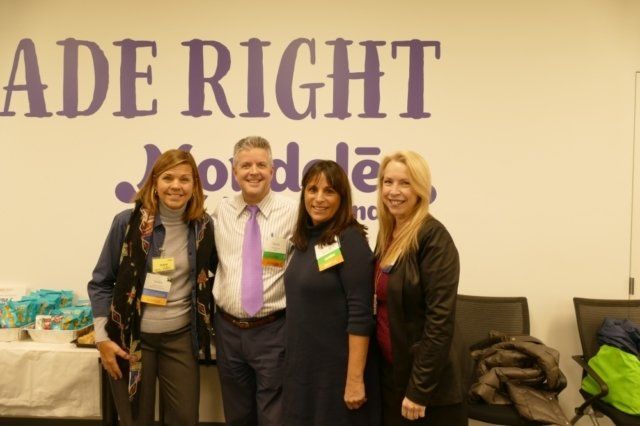 A group of people standing in front of a wall that says ade right