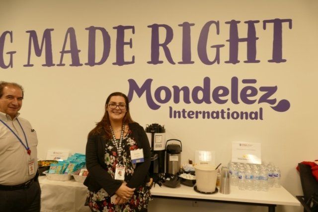 Two people standing in front of a wall that says mondelez international
