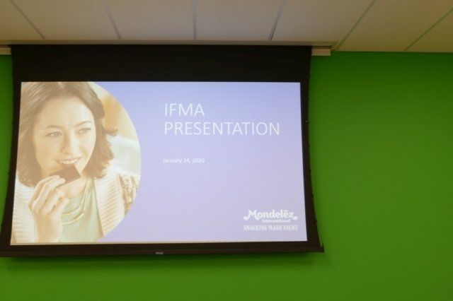 A projector screen shows a presentation about ifma
