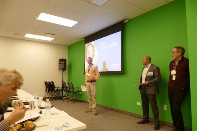 A group of men standing in front of a green wall