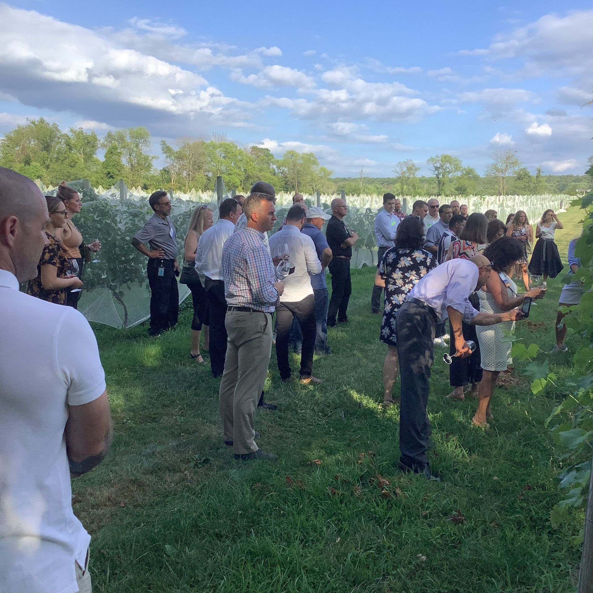 A group of people are standing in a grassy field.