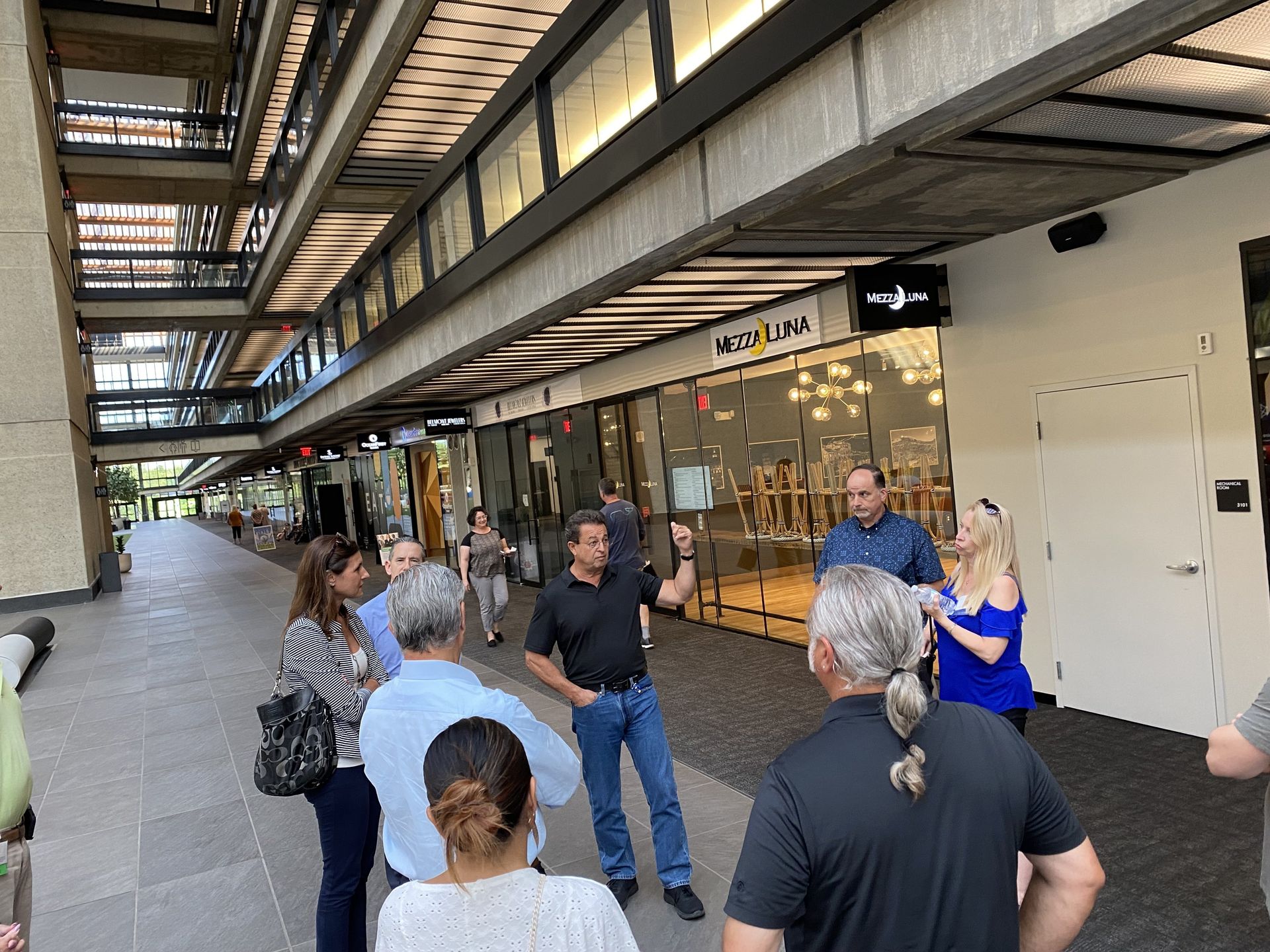 A group of people are standing in front of a building talking to each other.