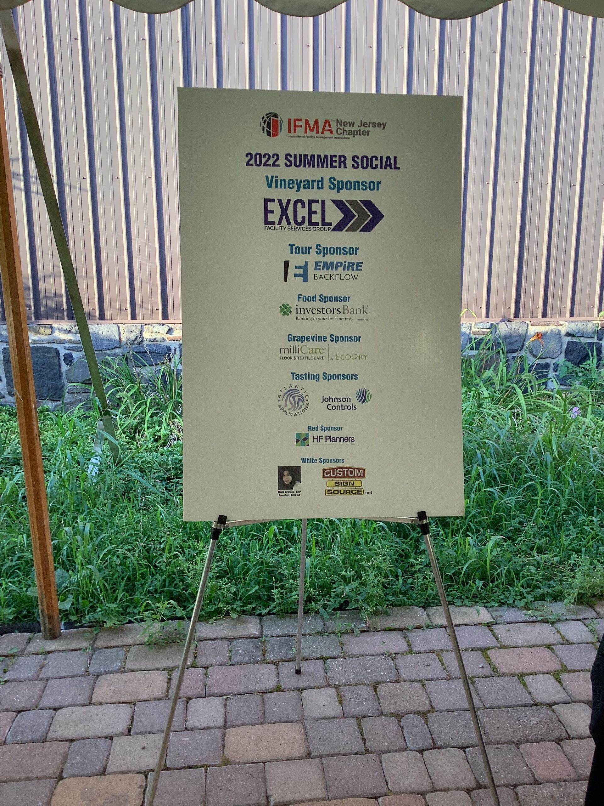 A sign that says excel is sitting on a easel in front of a tent.