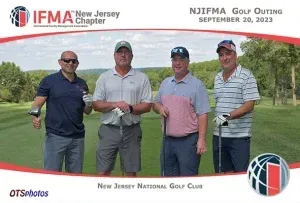 Four men are posing for a picture on a golf course