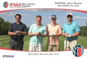 Four men are posing for a picture on a golf course