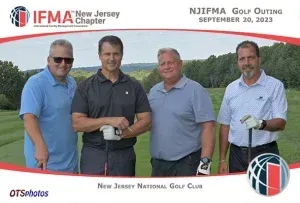 Four men are posing for a picture on a golf course