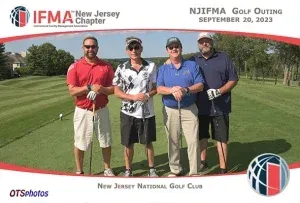 Four men are posing for a picture on a golf course