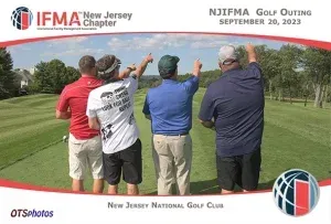 Four men are standing on a golf course and pointing at something