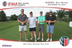 Four men are posing for a picture on a golf course