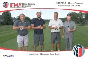 Four men are posing for a picture on a golf course
