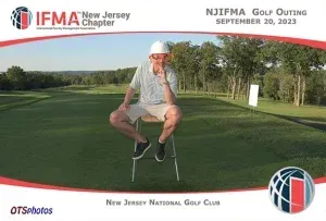 A man is sitting on a chair on a golf course