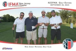 Four men are posing for a picture on a golf course