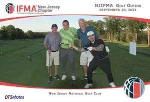 Four men are posing for a picture on a golf course sponsored by the new jersey national golf club