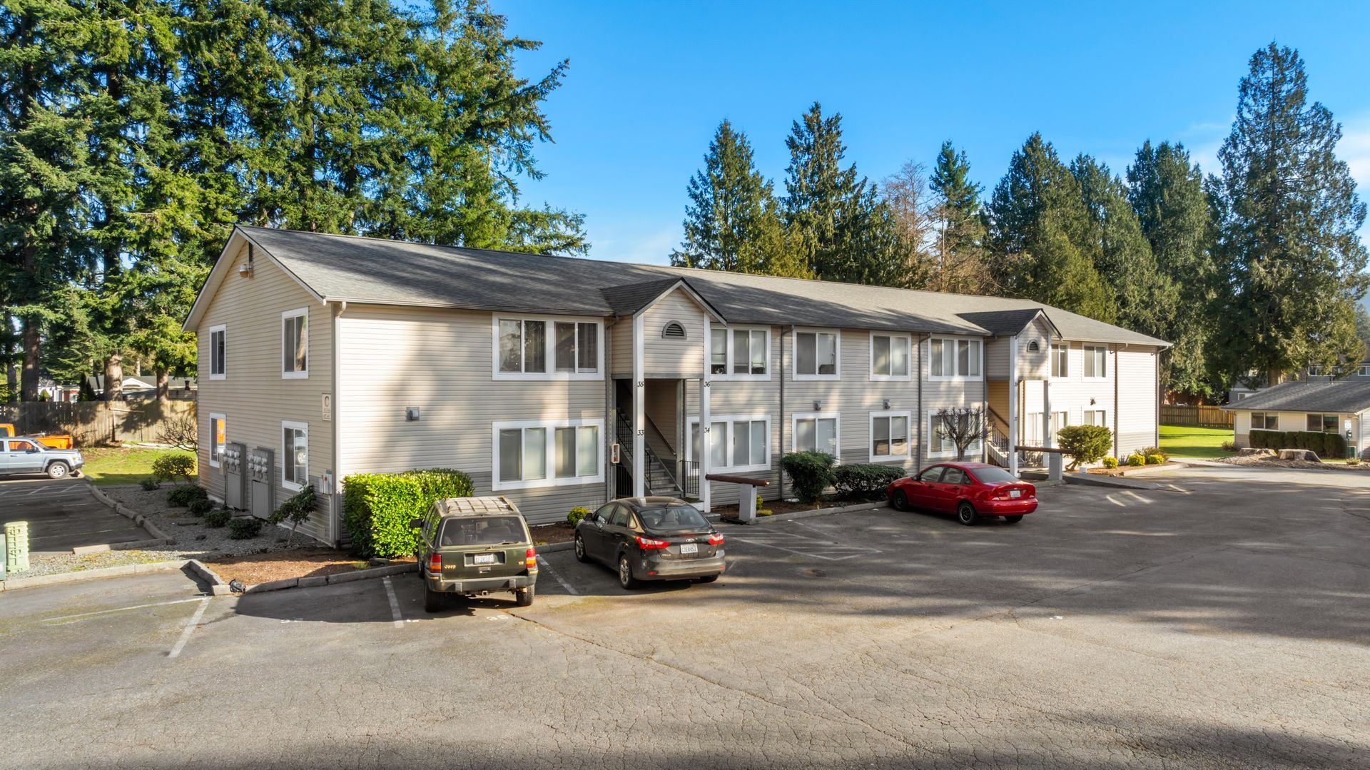 A large apartment building with cars parked in front of it.