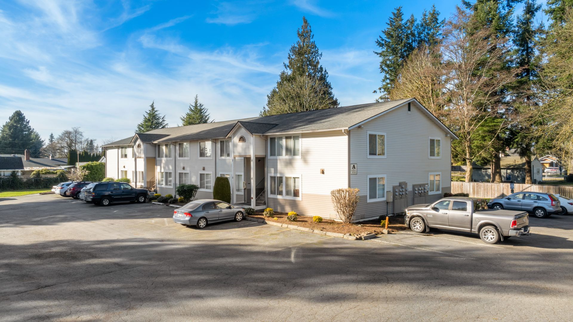 A large apartment building with cars parked in front of it.