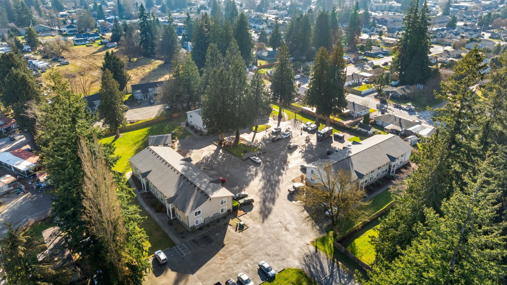 An aerial view of a house surrounded by trees in a residential area.