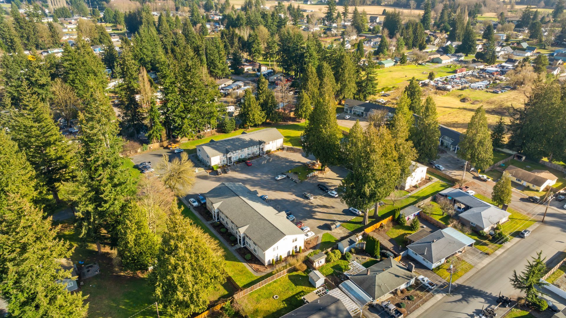 An aerial view of a residential area surrounded by trees and houses.