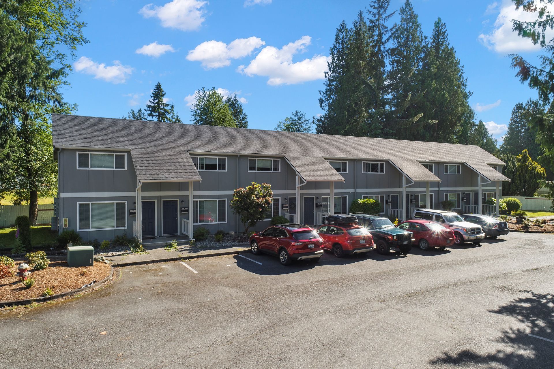 A row of cars are parked in front of a building