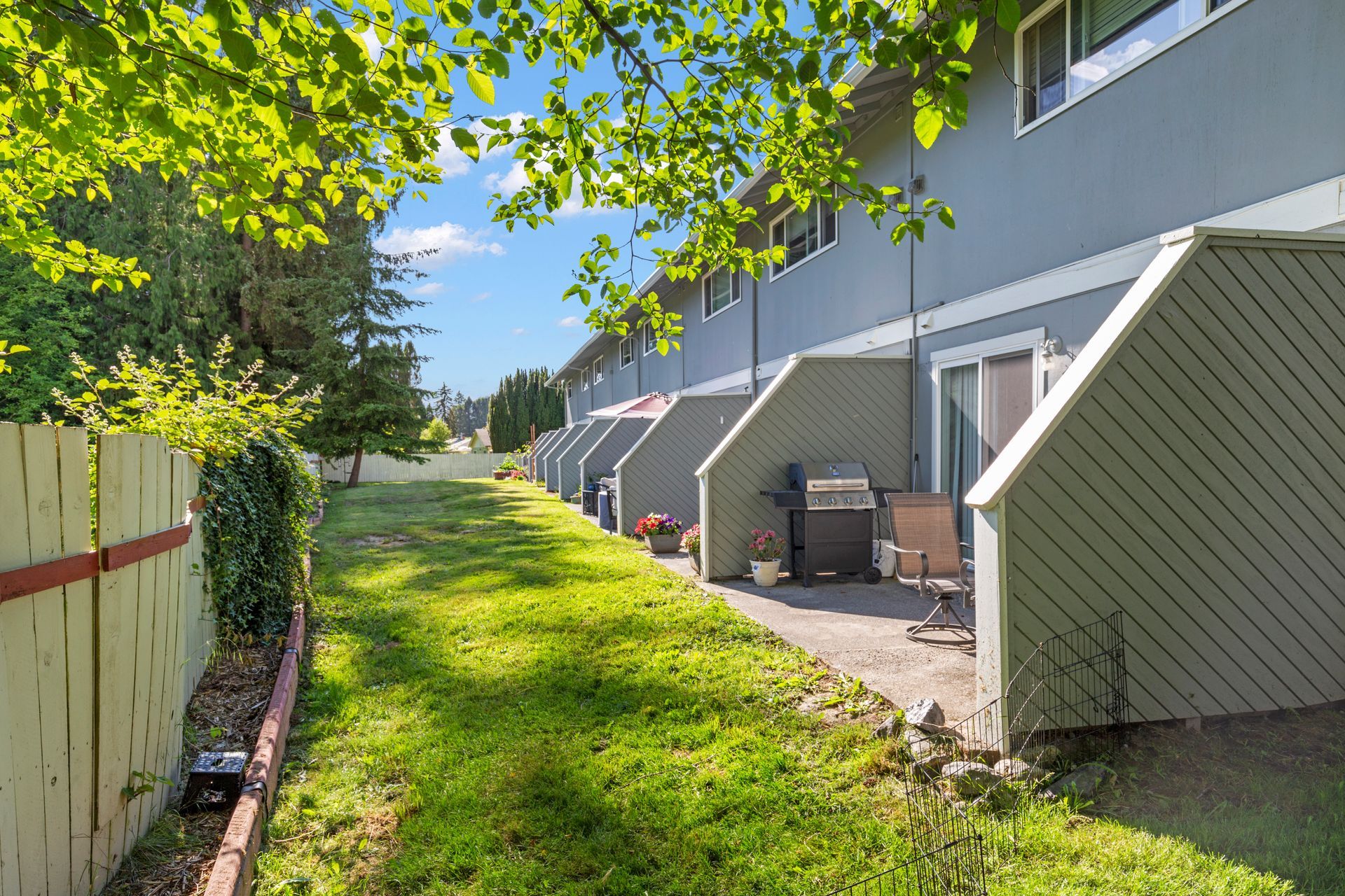 A row of houses with a fence and a patio in front of them.