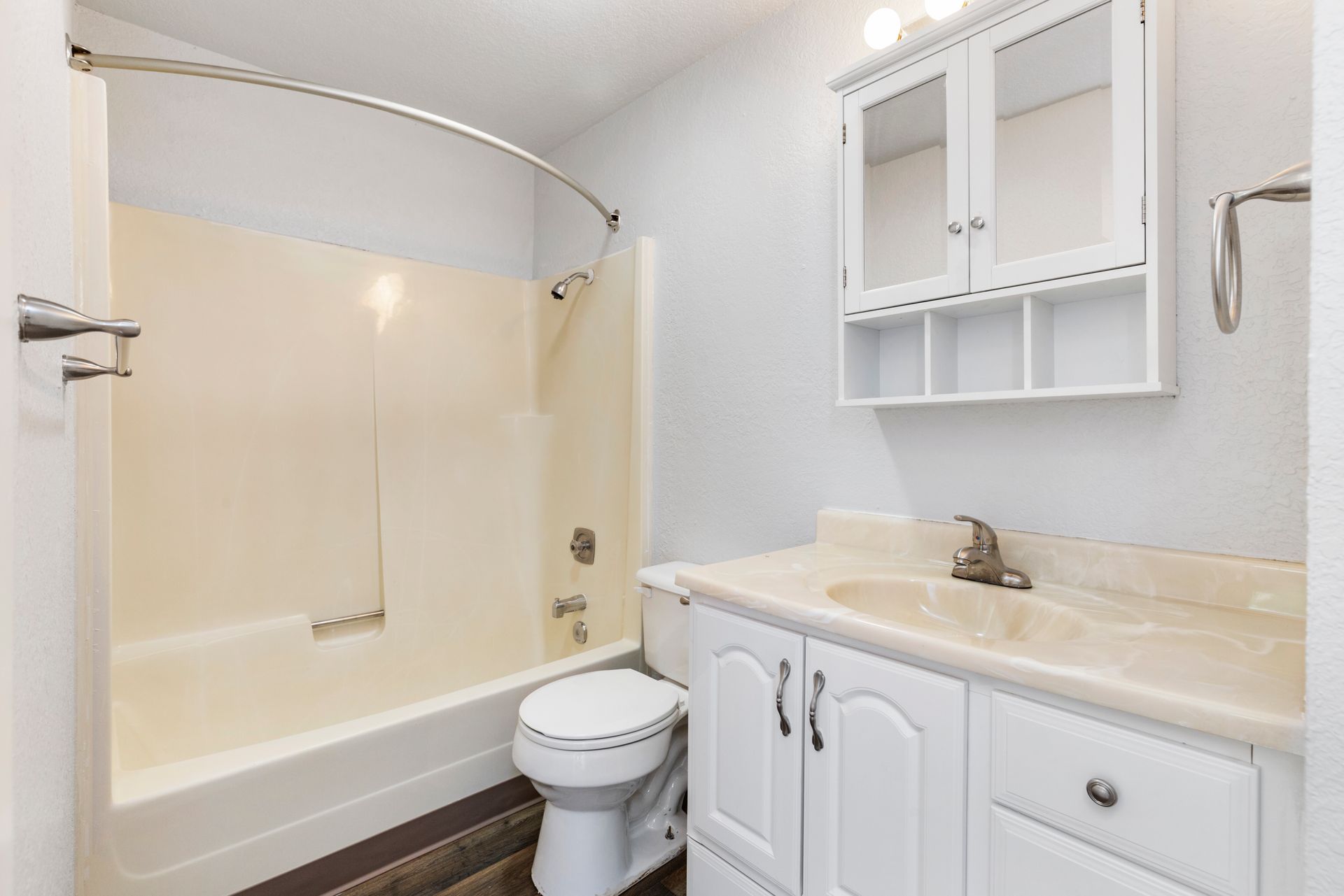 A bathroom with a toilet , sink , and bathtub.