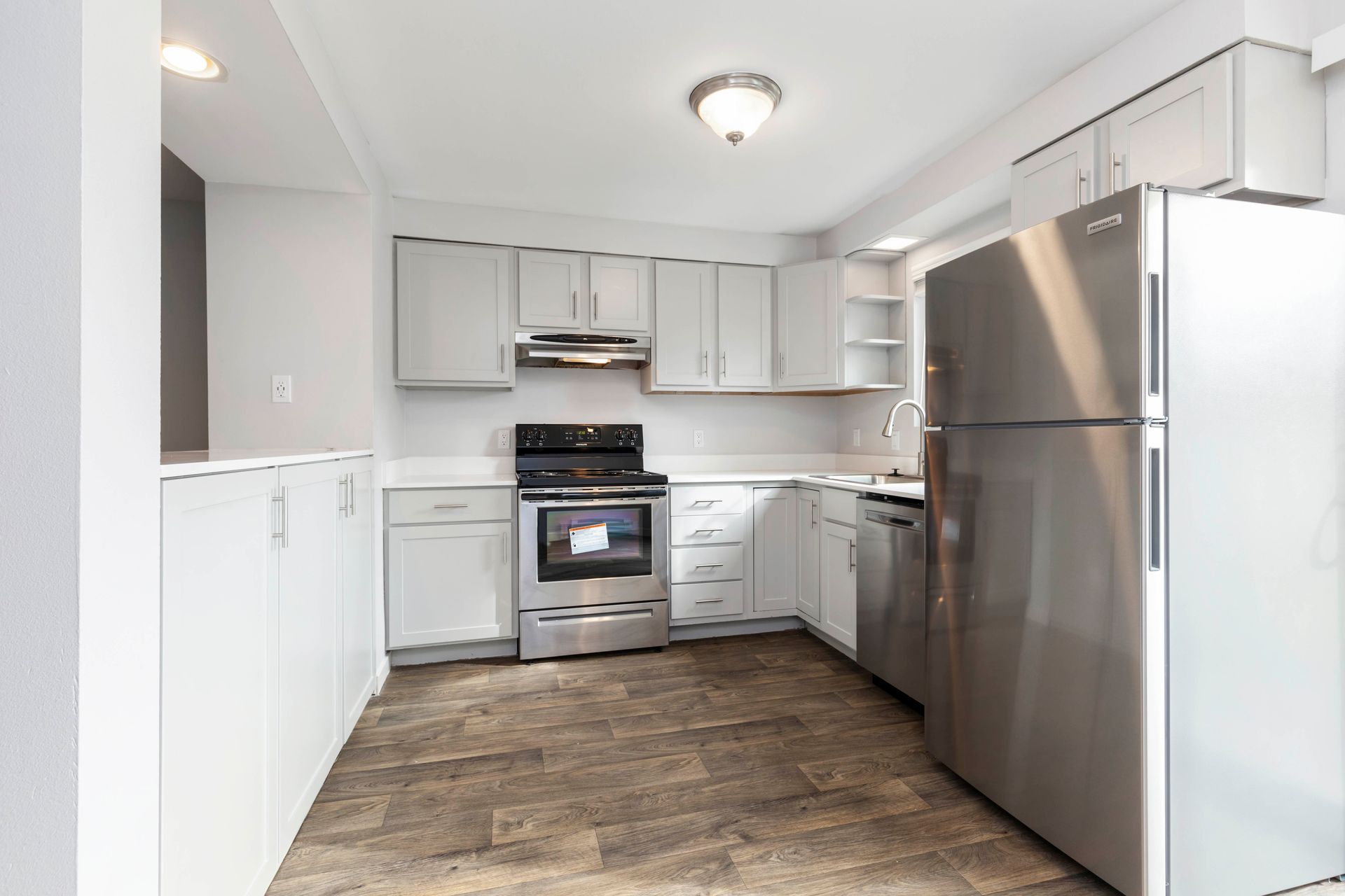 A kitchen with stainless steel appliances and white cabinets