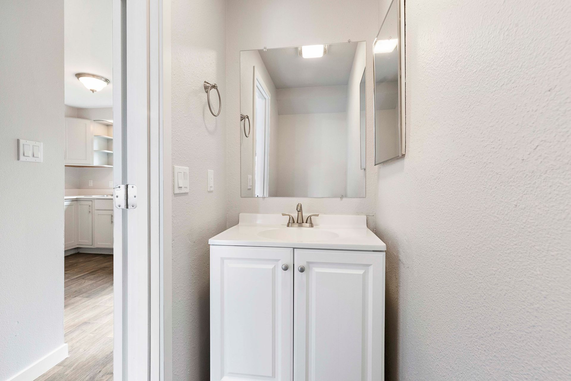 A bathroom with a sink , mirror and cabinets.