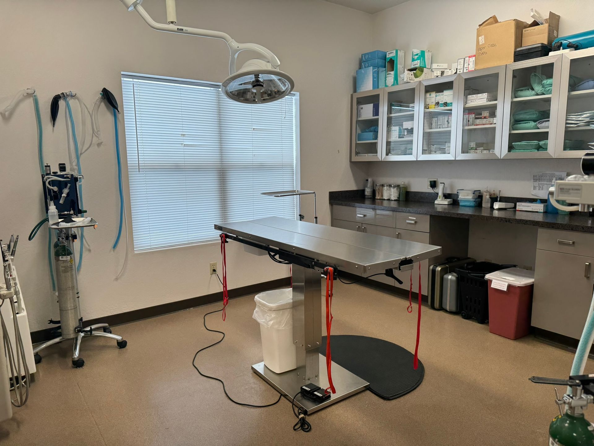 There is a surgical table in the middle of the room.