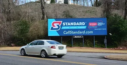 Car driving by a standard billboard