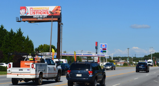 a billboard for dunkin donuts is above a highway