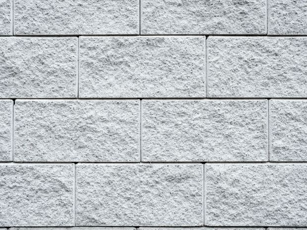 Light gray brick wall with textured surface and visible grout lines.