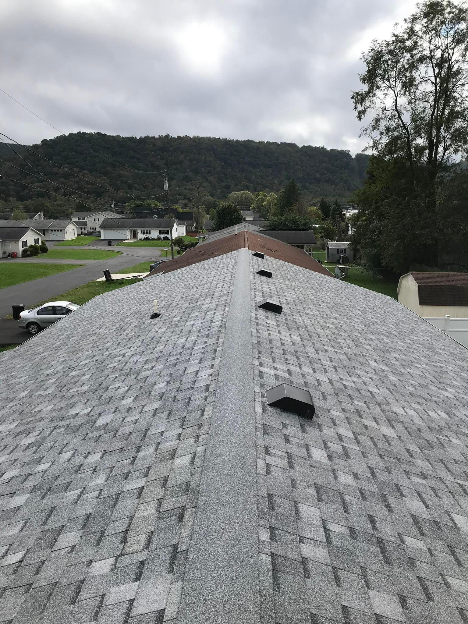 A roof with a lot of shingles on it and a mountain in the background.