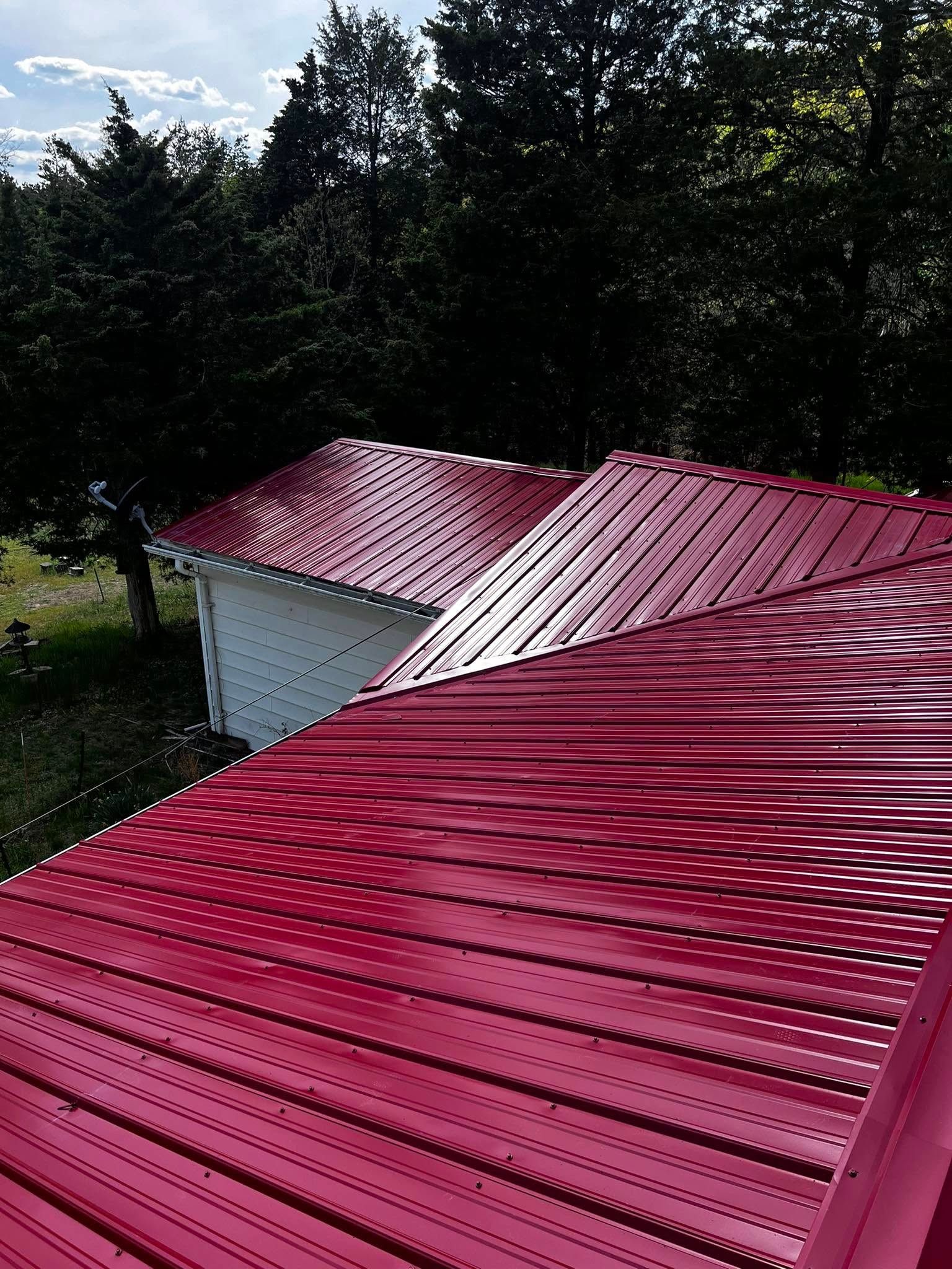A red metal roof is sitting on top of a white building.