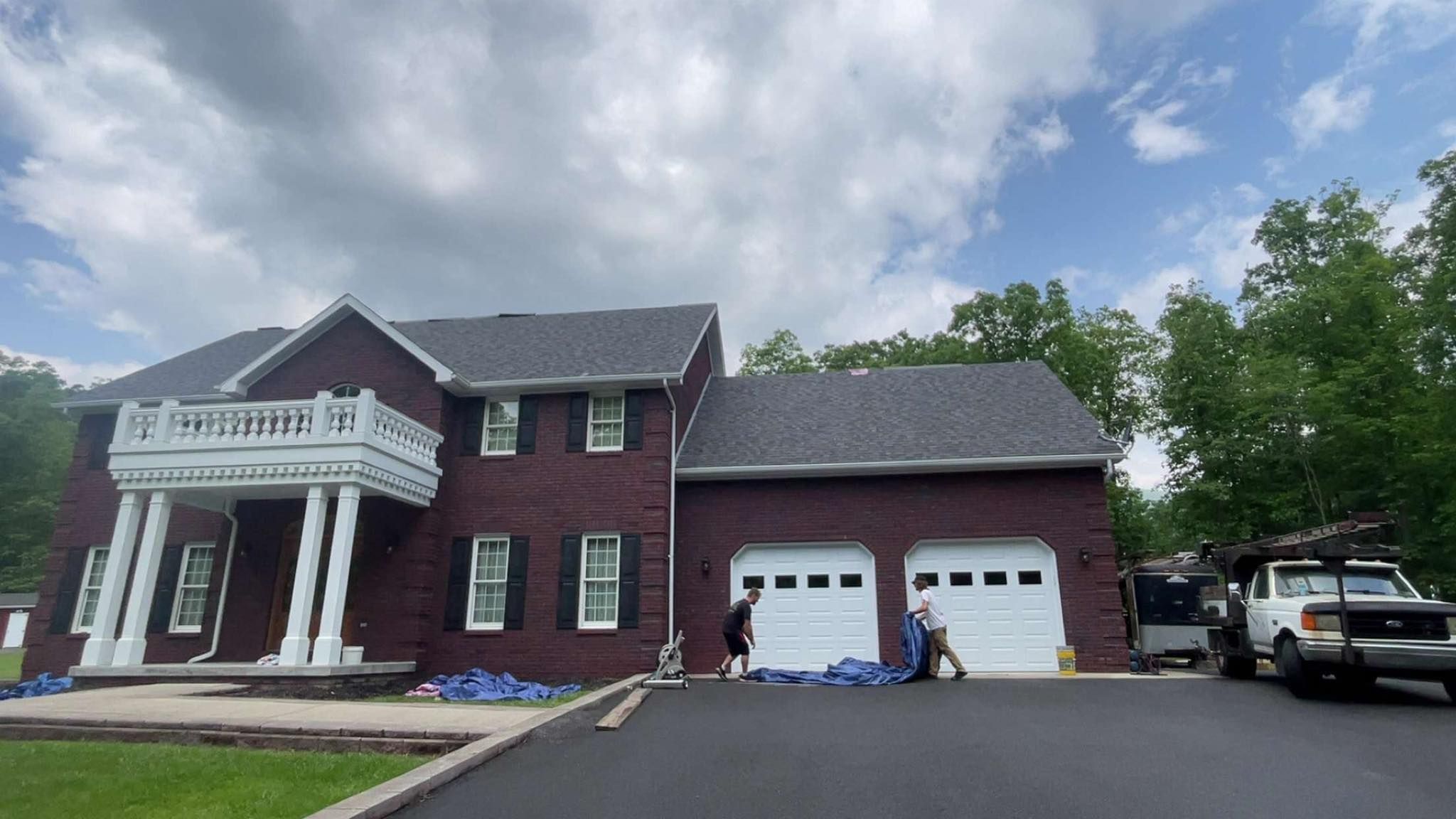 A large brick house with a truck parked in front of it.
