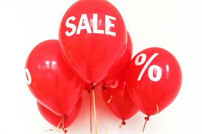 Rode ballonnen met daarop "SALE" en een procentteken gedrukt.