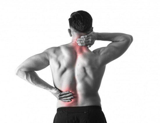 Man holding sore neck massaging cervical area suffering body pain — Chiropractic in Los Angeles, CA