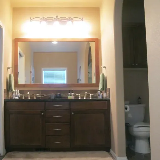 A bathroom with two sinks and a toilet