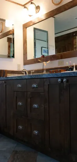 A bathroom with two sinks and a large mirror.