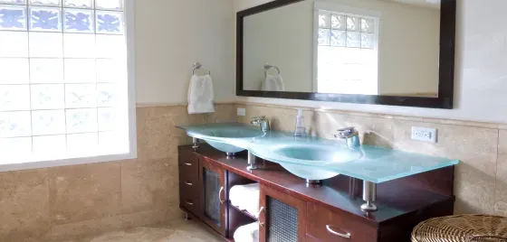 A bathroom with two sinks , a mirror and a window.