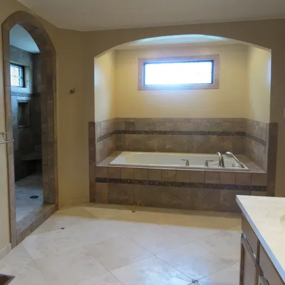 A bathroom with a large tub and a window