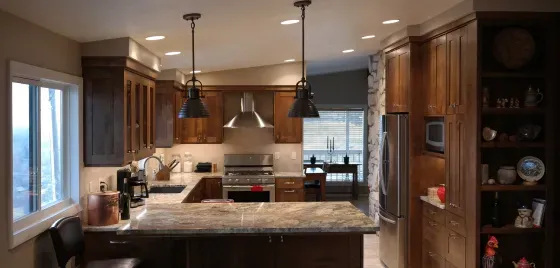 A kitchen with wooden cabinets , granite counter tops , stainless steel appliances and a large island.