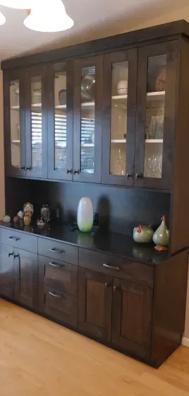 A kitchen with a lot of cabinets and glass doors.