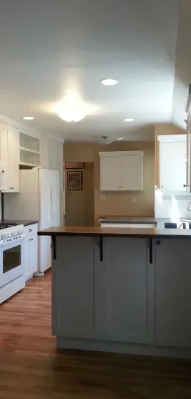 A kitchen with a large island and white cabinets