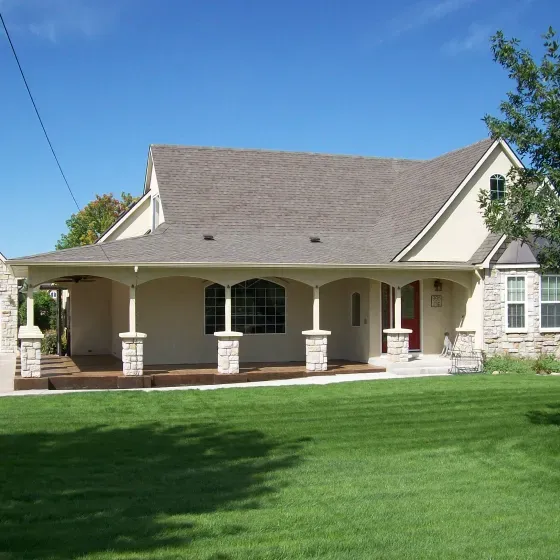 A white house with a porch and a red door