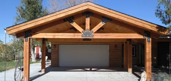 A wooden garage with a white door and a wooden roof.