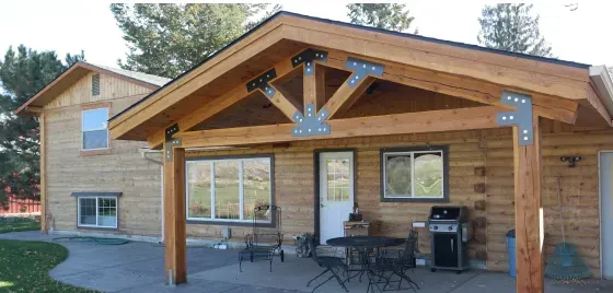 A wooden house with a covered porch and a table and chairs